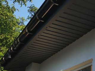 Пластиковый водосток и подшивы на крыше из металлопрофиля